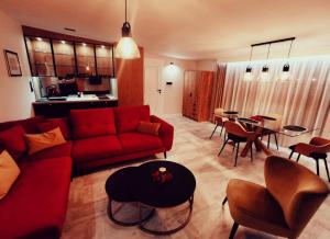 切哈努夫Apartament 34的客厅配有红色的沙发和桌子