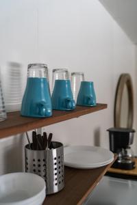 DeerwoodCuyuna Lakes Stay的架子上的厨房台,上面有三副蓝色玻璃杯