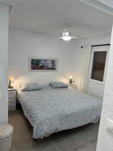 格兰阿利坎特Bungalow Santa Pola del Este的白色卧室配有带2个枕头的床