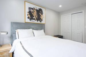 纽约350-2A Prime gramercy Newly renovated 1BR sleeps 4的卧室配有白色的床和墙上的绘画作品