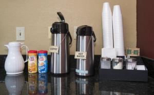 休斯顿GreenTree Inn - IAH Airpot JFK Blvd的一个带咖啡壶和一些杯子的台面