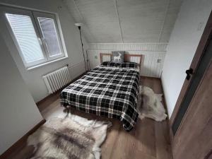 ChyšeChata s panoramatickou saunou的一间卧室配有一张床,床上铺有铺着条纹毯子