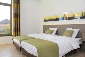 TubizeMondo hôtel的一间卧室设有两张床和大窗户