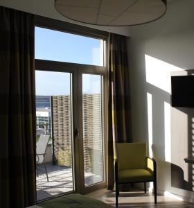 TubizeMondo hôtel的一间带椅子和滑动玻璃门的房间