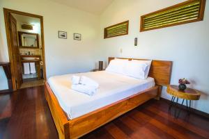 南圣胡安Verdad Nicaragua的一间卧室配有一张带白色床单和镜子的床