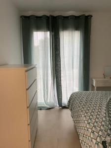 卡尔维Appartement lumineux T2 avec terrasse et jardin的一间卧室设有一张床和一个大窗户