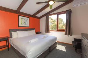 金德拜恩The Lakefront 69 Townsend Street的一间卧室配有一张带橙色墙壁的大床