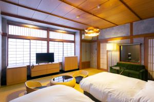 嬉野市吉田日式旅馆的酒店客房设有两张床和电视。