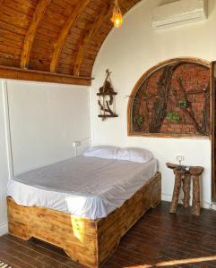 达哈布Dream house的一间卧室设有一张木床和木制天花板