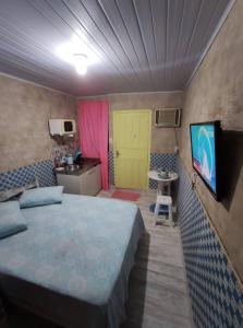 伊比拉奎拉Kitnet Barra de Ibiraquera的一间卧室设有一张床和一个黄色的门