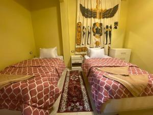 开罗Bella Casa Pyramids Inn的一间客房内配有两张床的房间