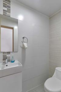 圣多明各Dom. Rep. Exclusive 2 bed Apt. Evaristo Morales的白色的浴室设有卫生间和水槽。