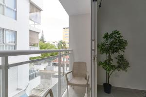 圣多明各Dom. Rep. Exclusive 2 bed Apt. Evaristo Morales的阳台配有椅子和盆栽植物