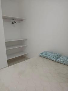 巴拉那州蓬塔尔Sol Nascente Apartamentos - Pontal do Sul的一间卧室设有一张床和白色的墙壁