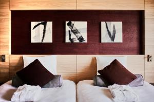 东京浅草豪景酒店的卧室配有两张床,墙上挂有图片