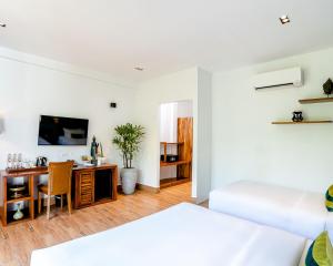 贡布RiverTree Villa & Resort的客厅配有一张床和一张书桌