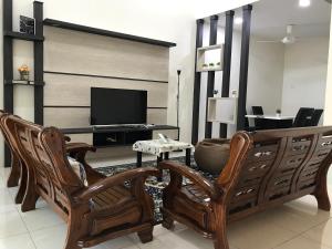 怡保Koolest homestays Meru的客厅配有两把椅子和电视