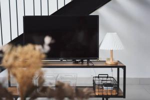 塞贝维Loft Style Duplex w/ Ultimate lakeview @ Sawtelle的一张桌子上的平板电视,配有台灯