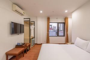 河内Coco Hotel Cau Giay的一间卧室配有一张大床和电视