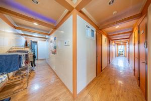首尔Dream Single House的走廊设有白色瓷砖墙壁和木制天花板