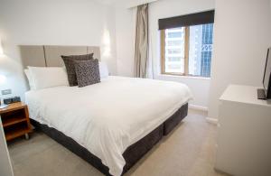悉尼Quay West 1301 Self- Catering的卧室设有一张白色大床和一扇窗户。
