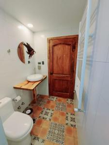百内三塔Morrena Lodge的一间带卫生间和木门的浴室