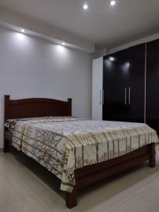 迈克蒂亚Apartamento frente al Aeropuerto de Maiquetía的一间卧室配有一张床和一个黑色橱柜