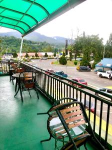 拉瑙MJ inn的一个带桌椅的阳台和一个停车场