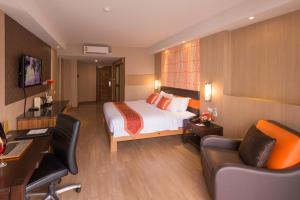 曼谷王朝格兰德酒店（原王朝格兰德旅馆）的配有一张床和一张书桌的酒店客房