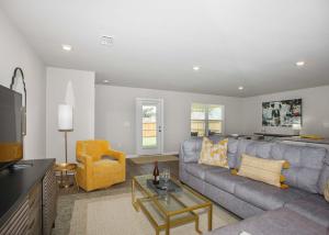 弗利Grand Getaway House的客厅配有灰色的沙发和黄色的椅子