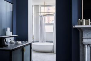 巴拉腊特Hotel Vera Ballarat的带浴缸的浴室和窗户。