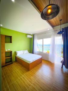 马比尼Anilao Ocean View Guest House的一间卧室设有一张床和一个大窗户