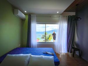 马比尼Anilao Ocean View Guest House的一间卧室设有一张床和一个美景窗户。