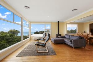 Lake TyersLake Tyers Beach House的带沙发、椅子和窗户的客厅
