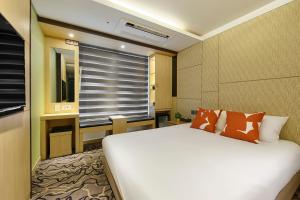 西归浦市JEJU Western Grace Hotel的卧室配有白色的床和窗户。