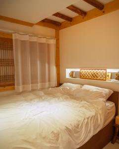 庆州Stay Gyeongju的卧室配有一张大白色床和窗户