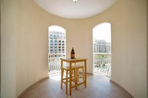 迪拜Lux Living on Palm Jumeirah With Beach Access & Complimentary Golf的一间设有桌子和两个窗户的房间