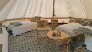 诺托登Lystang Glamping & Cabins的带2张床和桌子的帐篷客房
