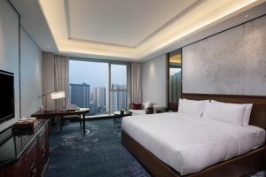乐山乐山华邑酒店的酒店客房设有一张床和一个大窗户