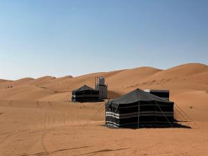 BadīyahMoon Light Camp的沙漠中的一组帐篷