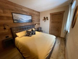 萨奥兹-杜尔克斯Apartment Gran Baita Sauze d'Oulx的一间卧室配有一张木墙床
