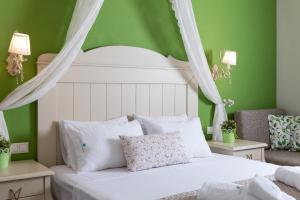 利迈纳里亚Villa Anthelion的一间卧室配有白色的床和绿色的墙壁