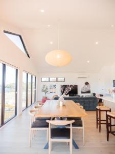 霍巴特Luxurious Waterfront home in the North of Hobart的用餐室以及带桌椅的起居室。