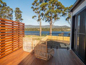 霍巴特Luxurious Waterfront home in the North of Hobart的一个带椅子的甲板,享有水景