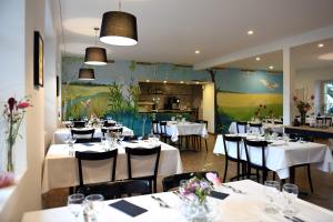 屈德勒凡Auberge de La Sauge的餐厅配有桌椅和白色的桌布