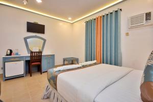 长滩岛Royal Park Resort Boracay的一间卧室配有一张床和一张带镜子的书桌