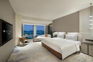 深圳深圳深铁铂尔曼酒店的卧室配有一张白色大床和电视。