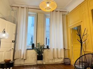 索恩河畔沙隆Le boudoir de Clem的一间设有白色窗帘和窗户的客房