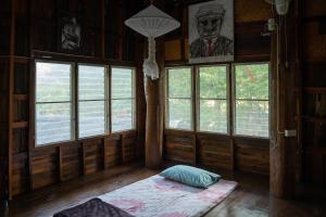 清道Art House at Chiangdao - Waterlily House的客房设有窗户和地板上的床垫。