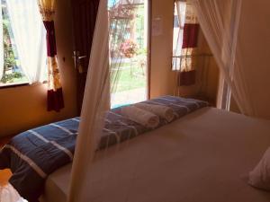 武吉拉旺武吉拉旺托马斯休闲度假旅馆的卧室内的一张床位,带窗户